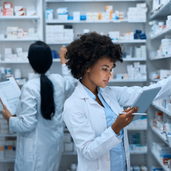 Pharmacist checking her tablet inside a pharmacy.